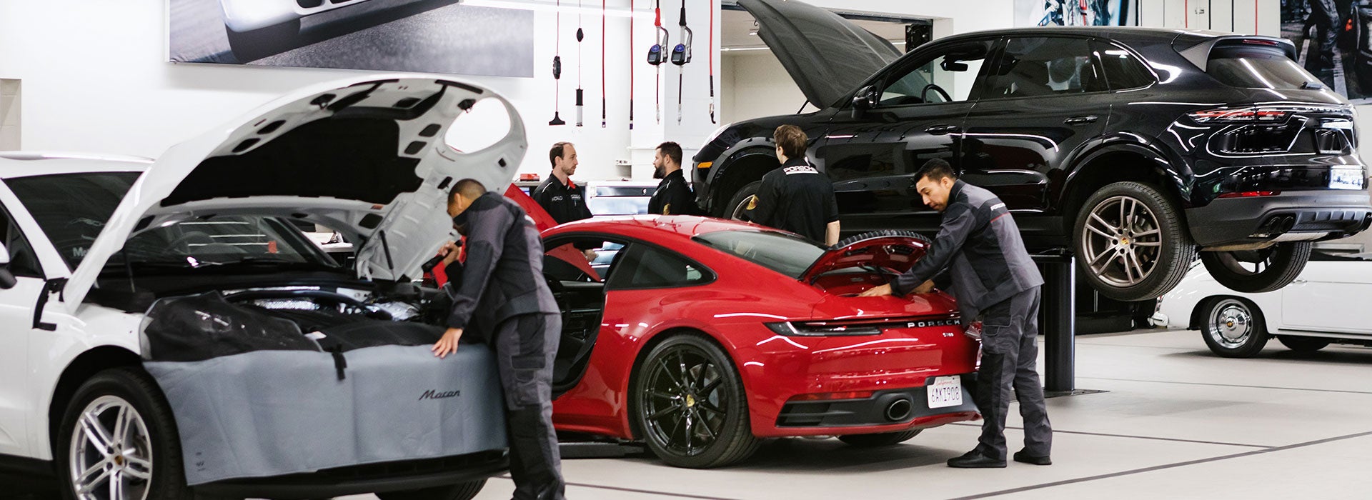Porsche Service Technicians performing regular maintenance on various Porsche models