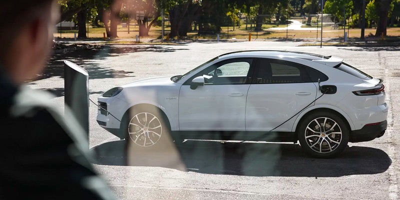 A white 2024 Porsche Cayenne Coupe parked in a parking lot on a sunny day